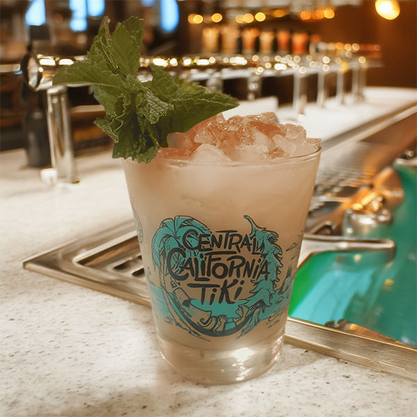 pistachio orgeat in a mai tai glass branded with central california tiki in a cocktail bar setting