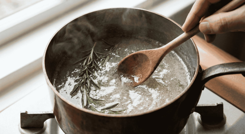 rosemary simple syrup cooking in a saucepan